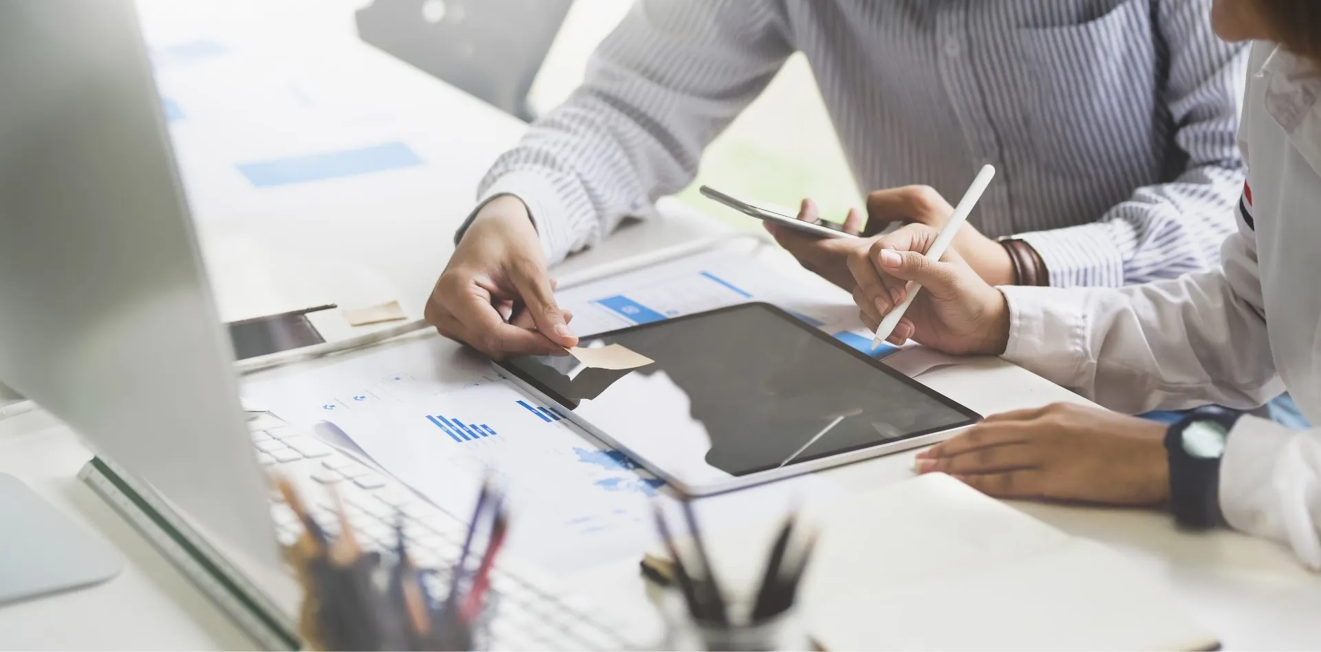 Bild: Hände zeigen etwas auf Tablet