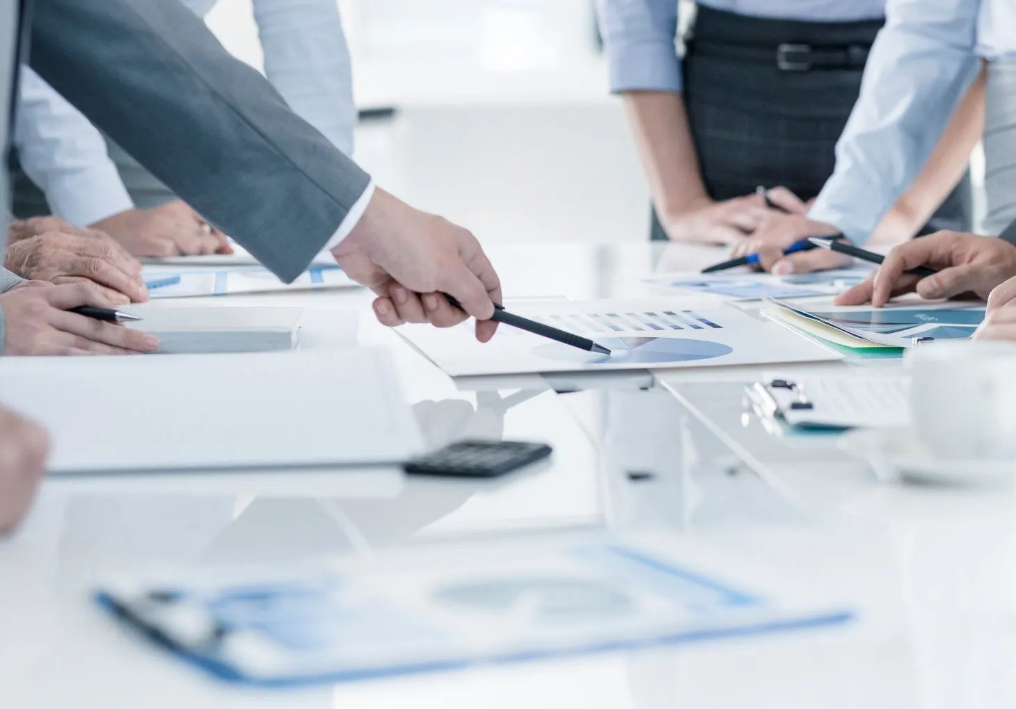 Bild: Menschen zeigen auf Papiere auf dem Tisch