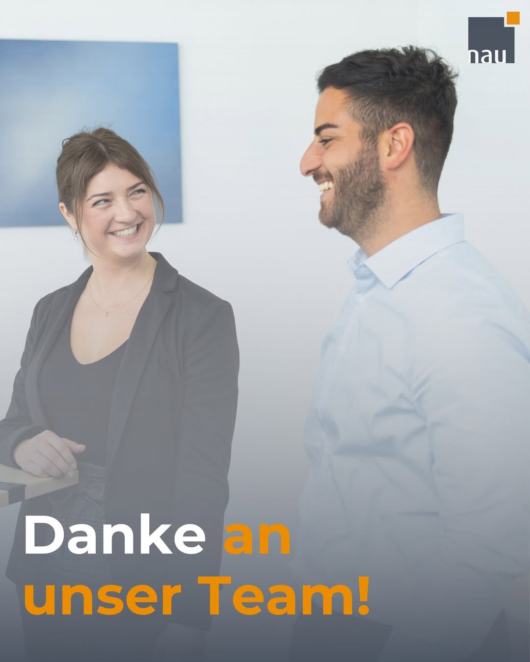 Zwei Mitarbeitende unterhalten sich vor einer Wand, Bildaufschrift „Danke an unser Team“.